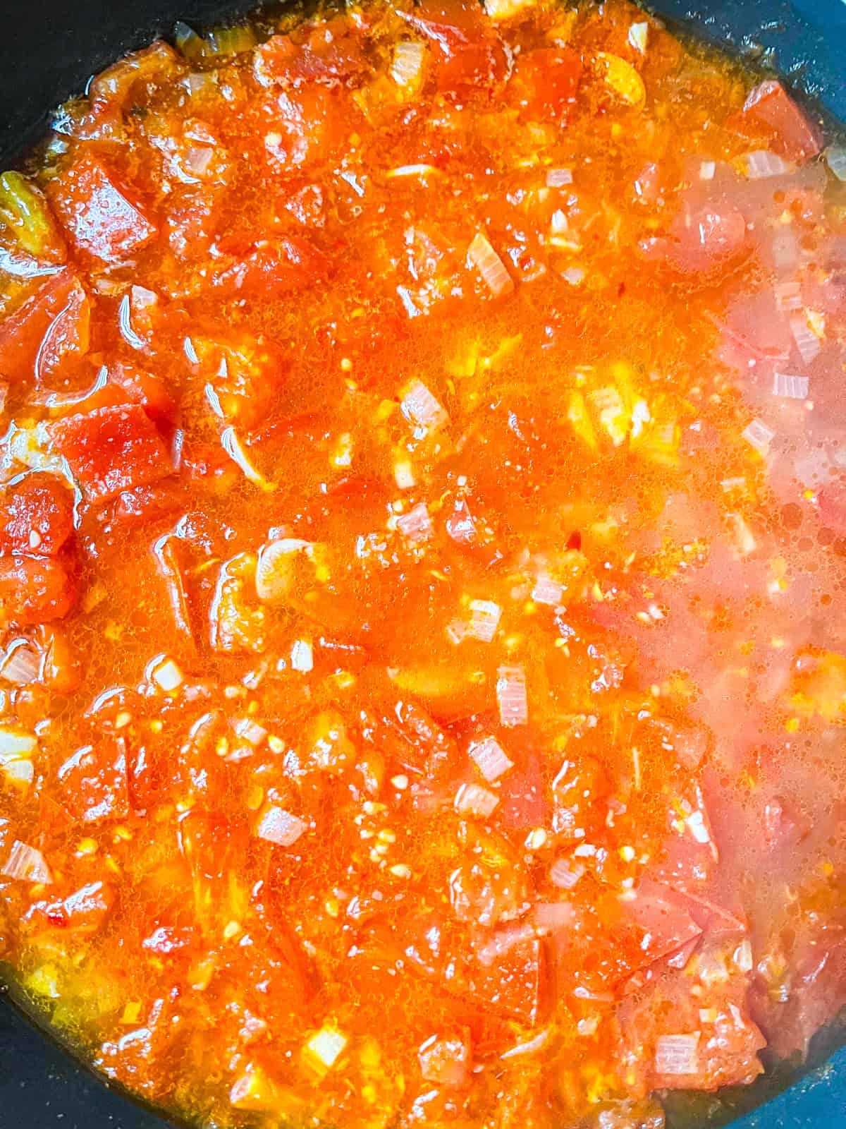Tomatoes cooked down and simmering.