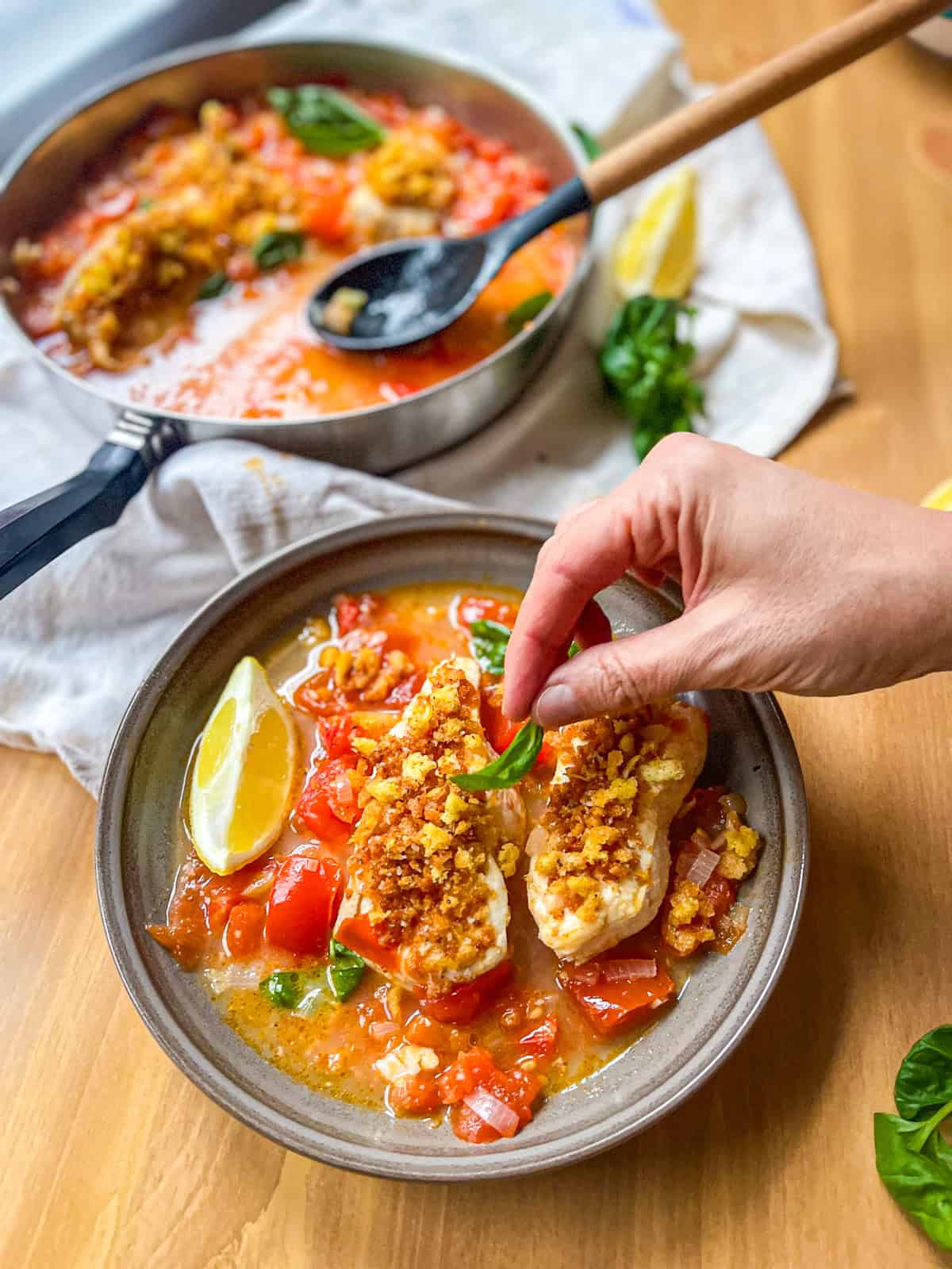 Poached fish in spicy tomato broth in a bowl and a pan.