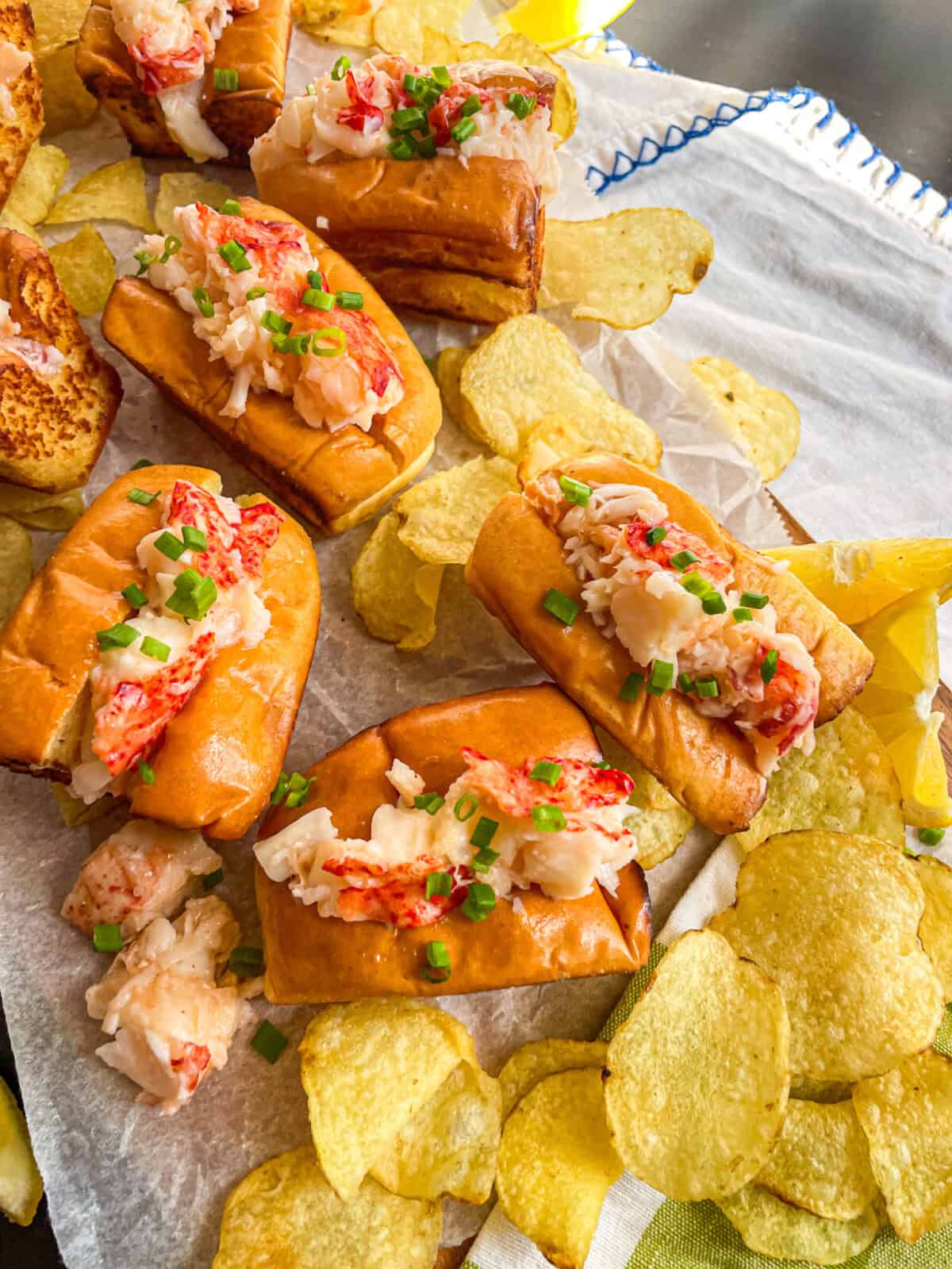 Mini Lobster rolls ion a tray with chips.