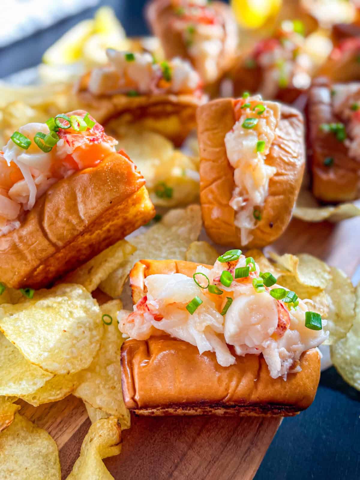 Lobster rolls on a platter with chips.