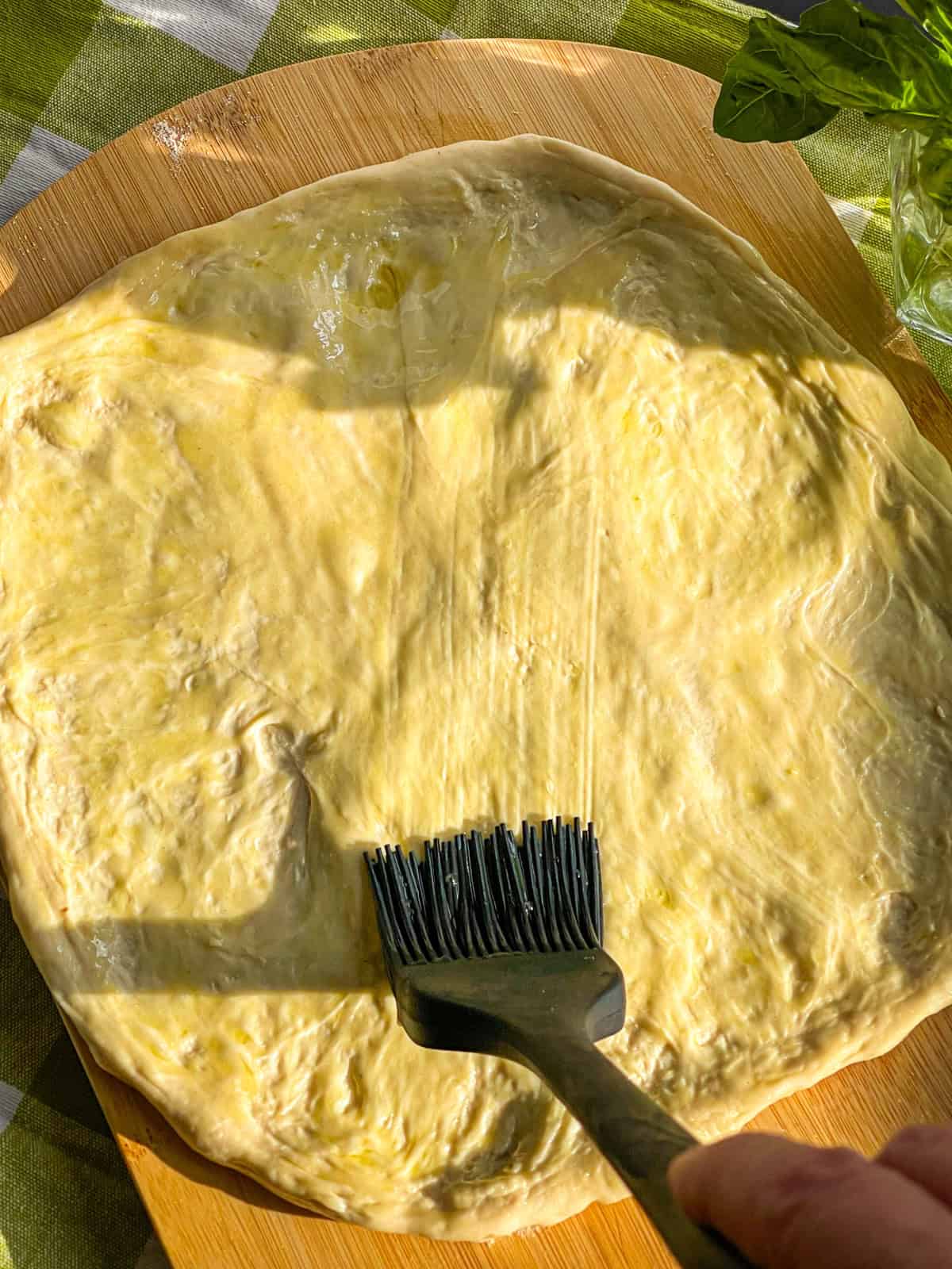 Olive oIl spread over dough.