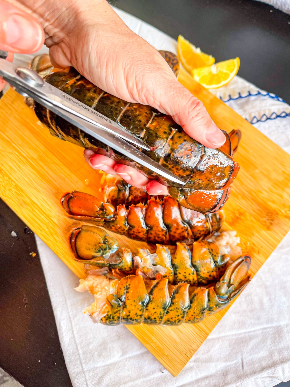 Lobster tail being split open with scissors.