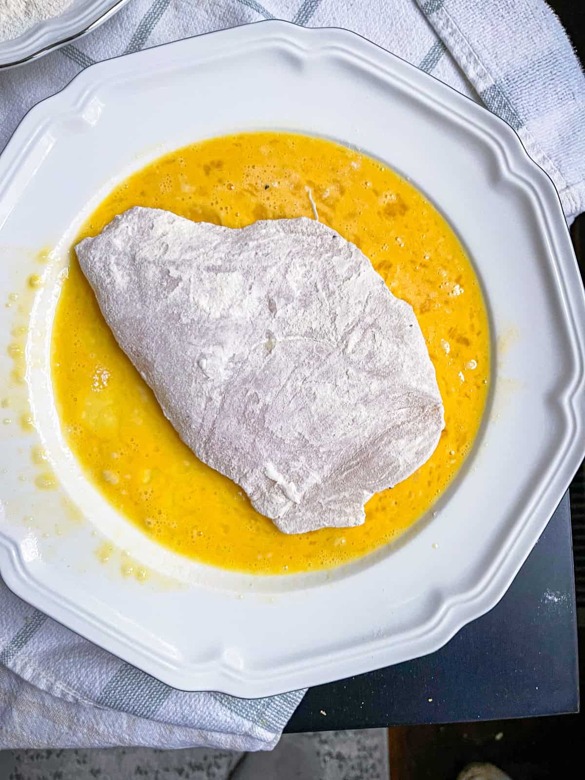 Halibut cheek dusted in flour and set in egg wash.