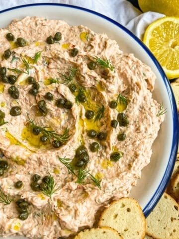 Creamy smoked salmon dip garnished with lemon, capers, dill and olive oil.