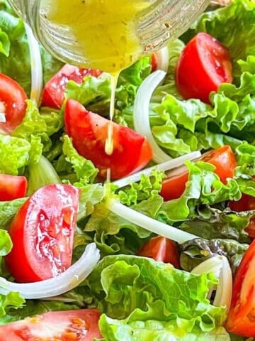 Salad dressing drizzling over a bright, fresh salad.
