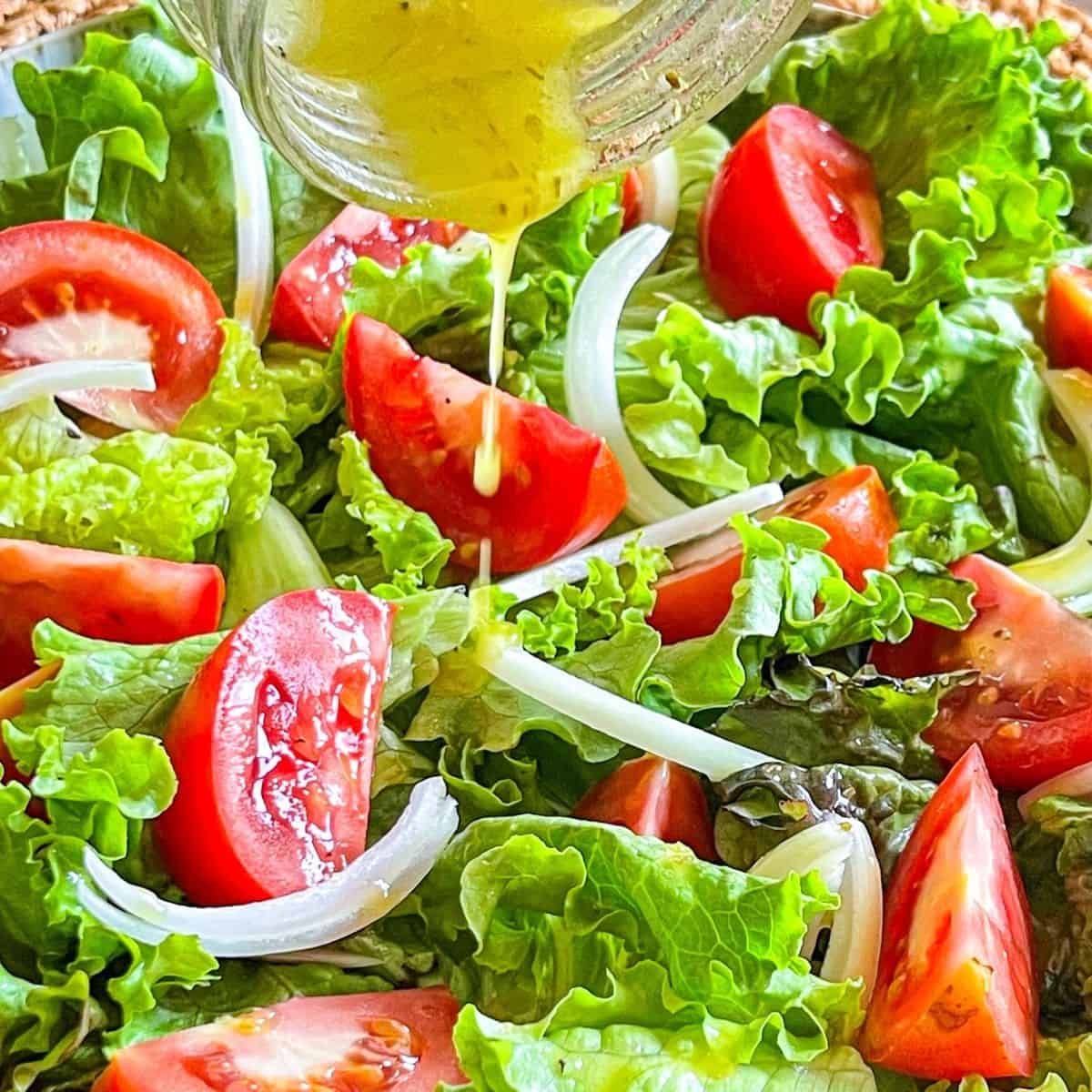 Salad dressing drizzling over a bright, fresh salad.
