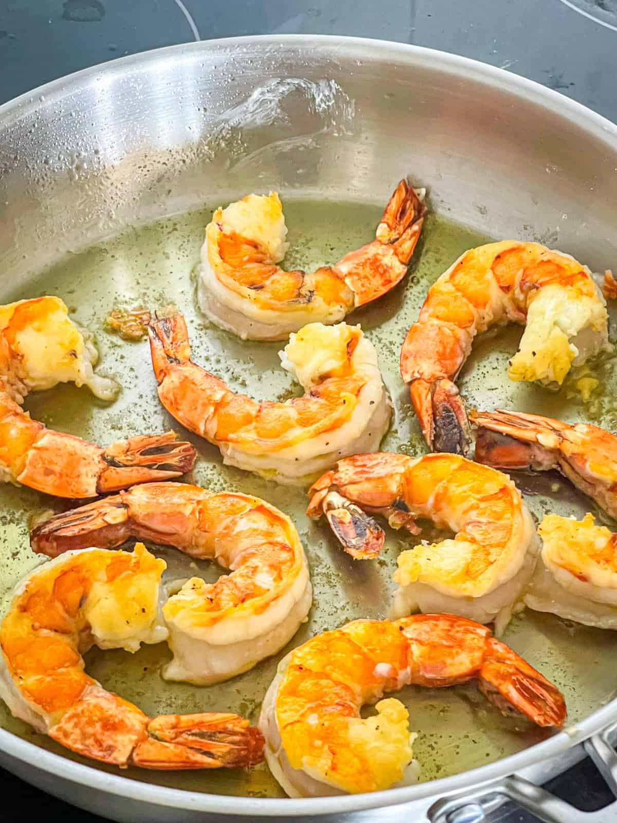 Shrimp seared in skillet.