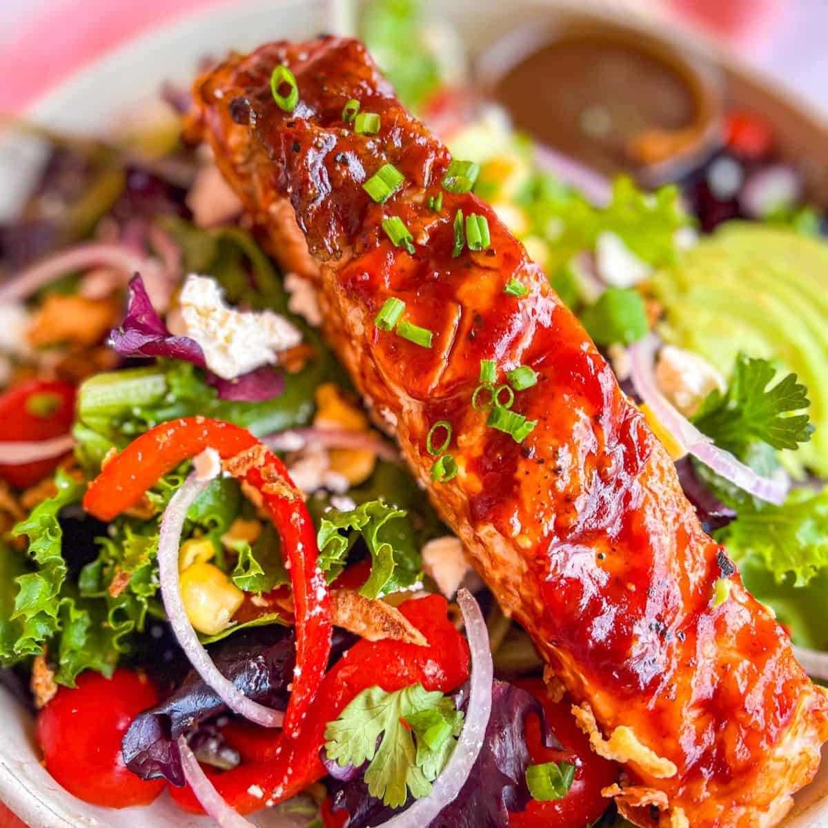 Grilled Salmon Salad garnished with chives.