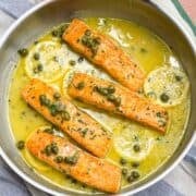 Salmon in lemon caper sauce in a skillet