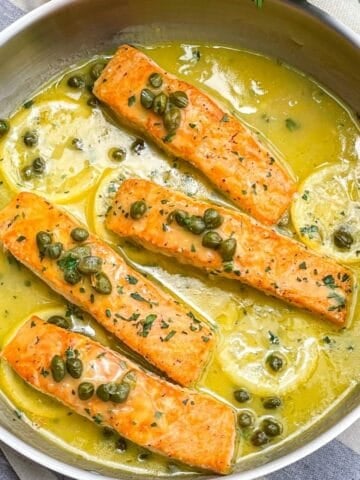 Salmon in lemon caper sauce in a skillet