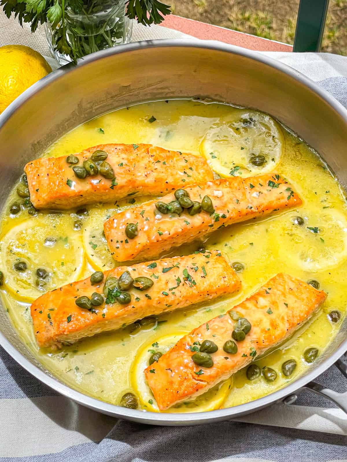 Salmon in lemon caper sauce in a skillet