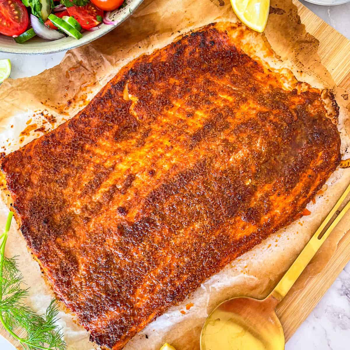 Salmon Shawarma on a parchment-lined board garnished with lemons.