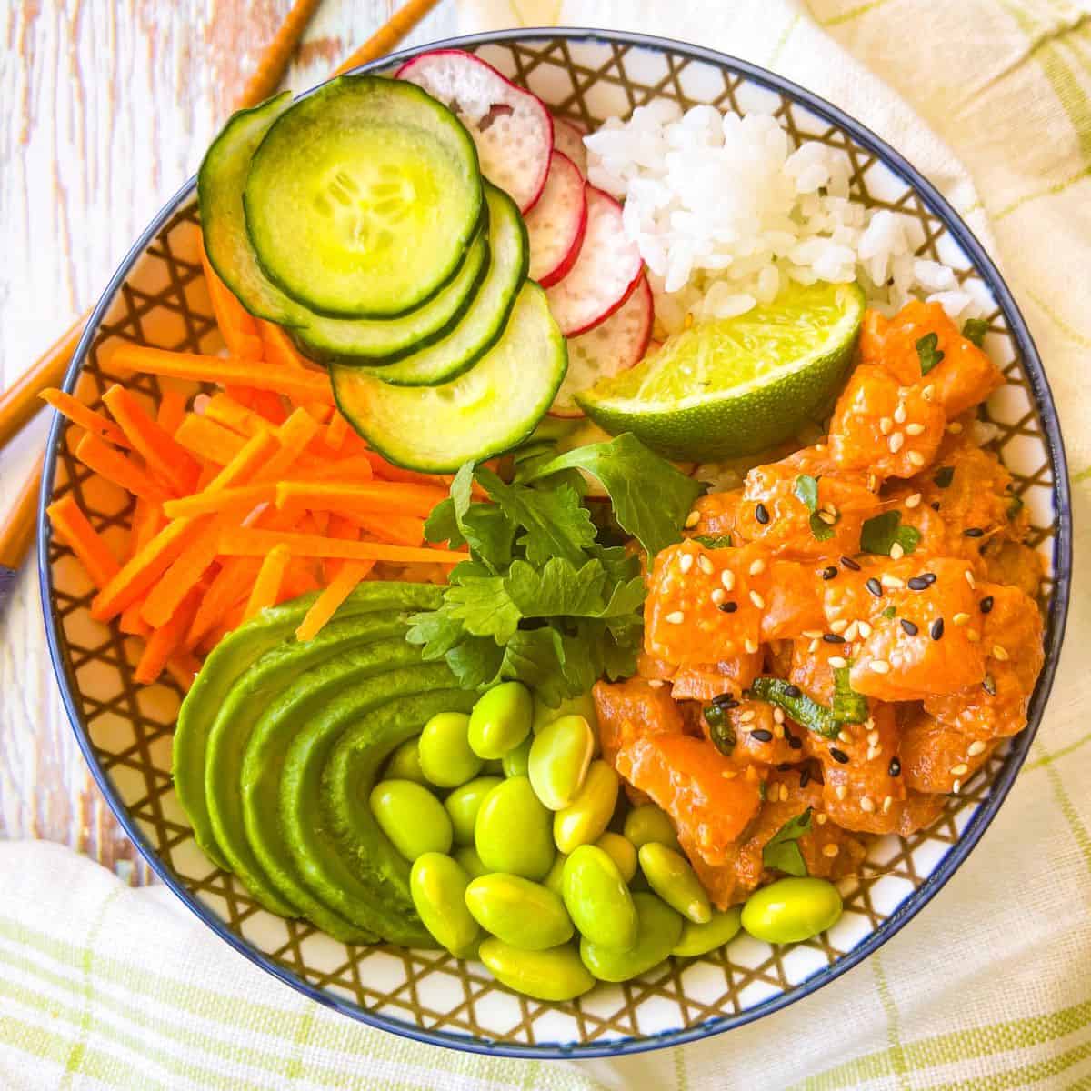 Spicy Salmon Sushi Roll presented in a bowl with fresh veggies and rice.