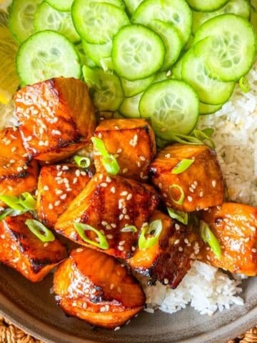 HIbachi Bites in a bowl with rice and cucumber.