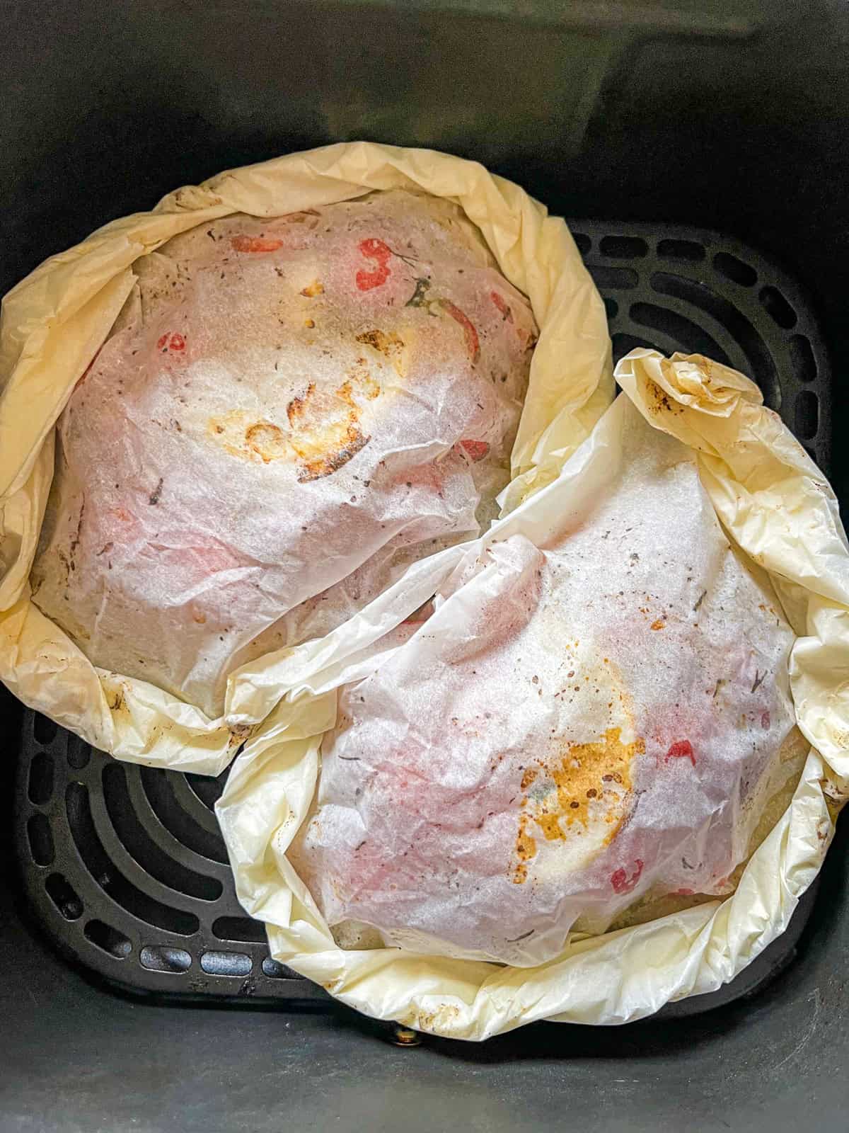 parchnemt package with pollock and tomato dill mix in air fryer.