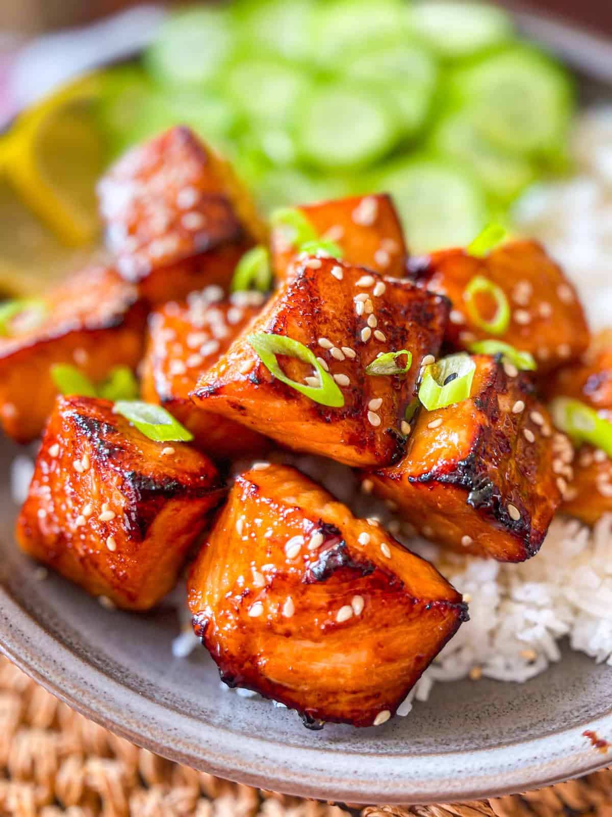 Hibachi Salmon bite over a ed of rice and side of cucumber.