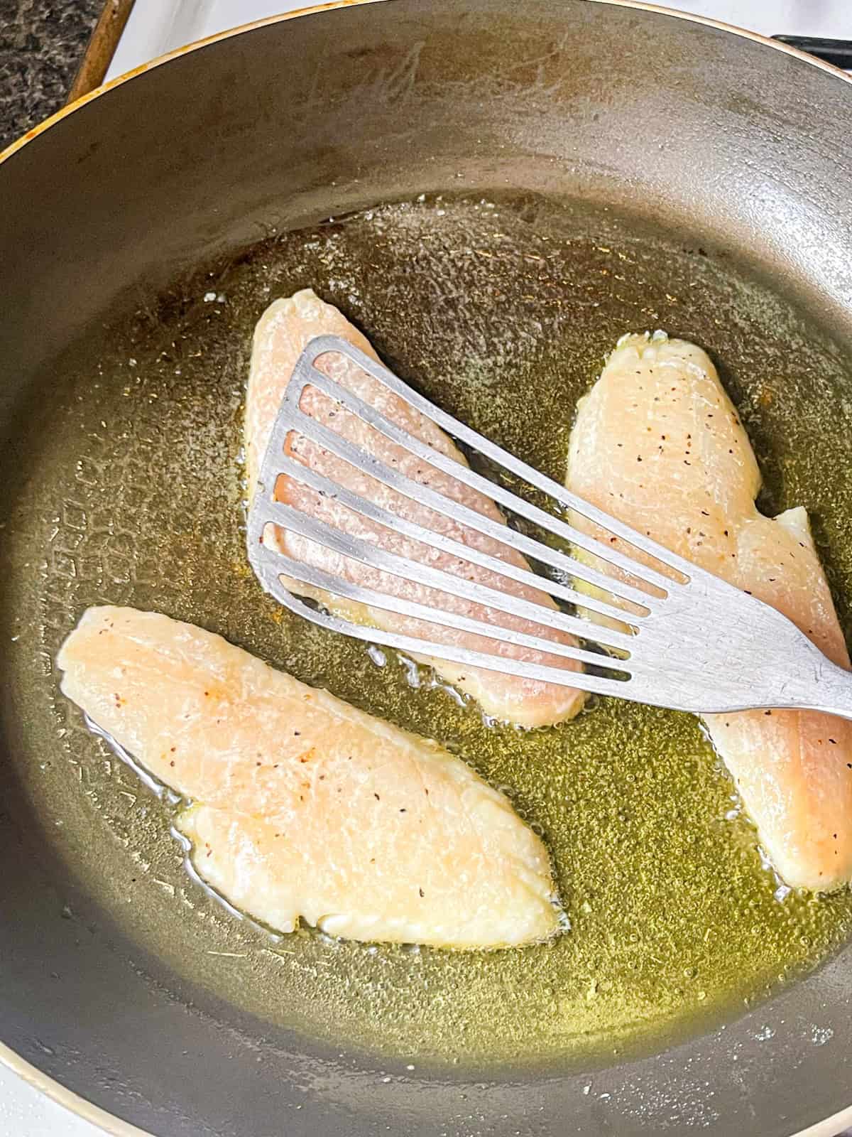 sea bass cooked skin side down on a skillet