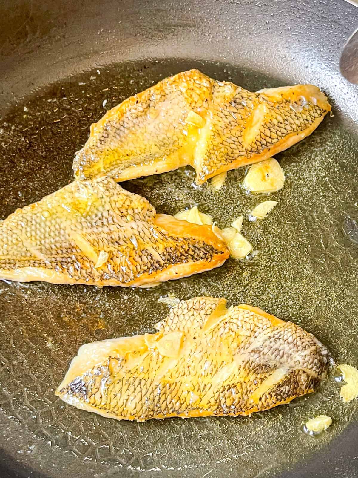 sea bass cooked skin side up on a skillet