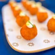 Salmon croquettes lined on a platter.