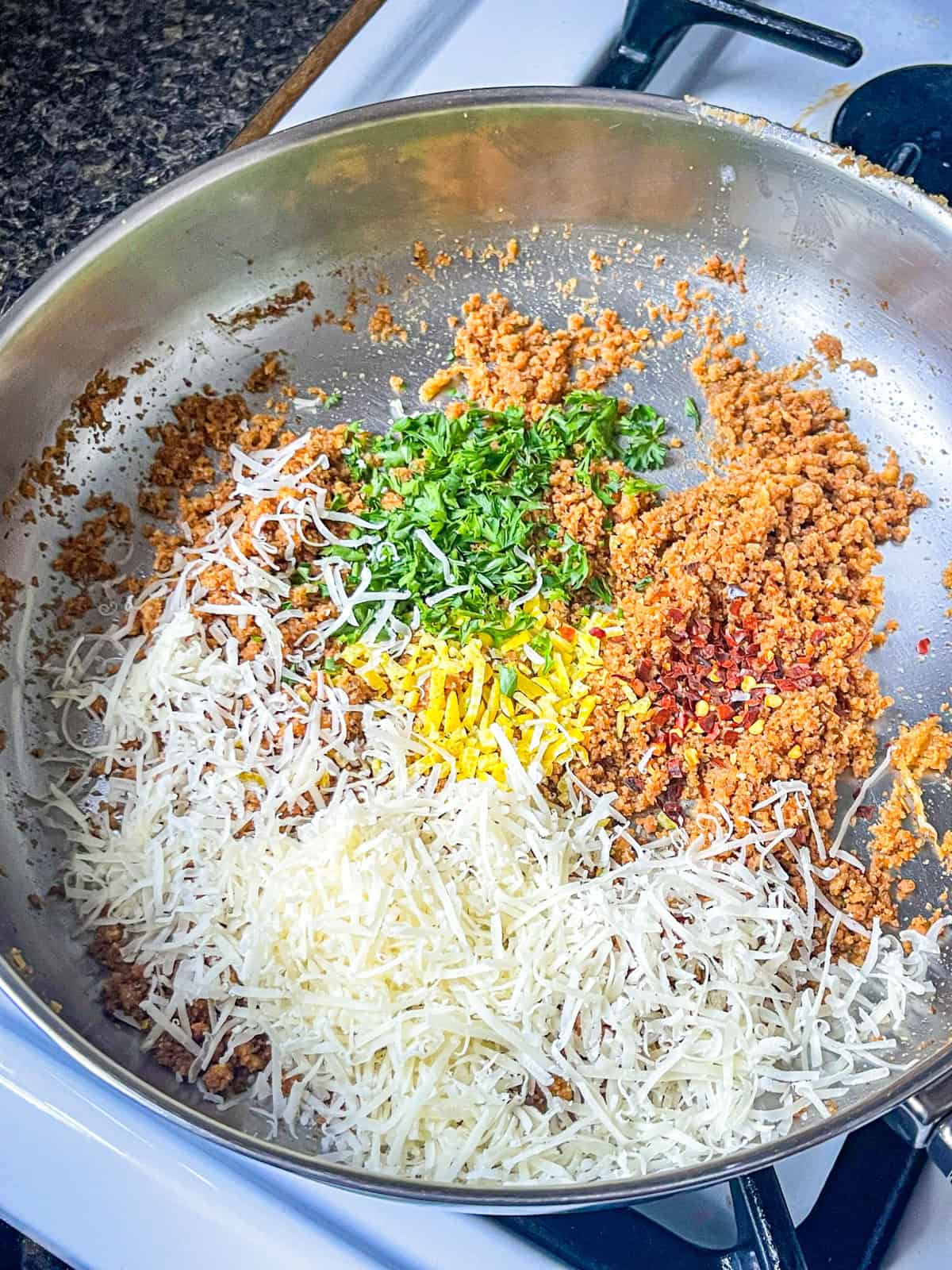 Parmesan, parsley, lemon zest, and red pepper tossed in a skillet with browned bread crumbs.