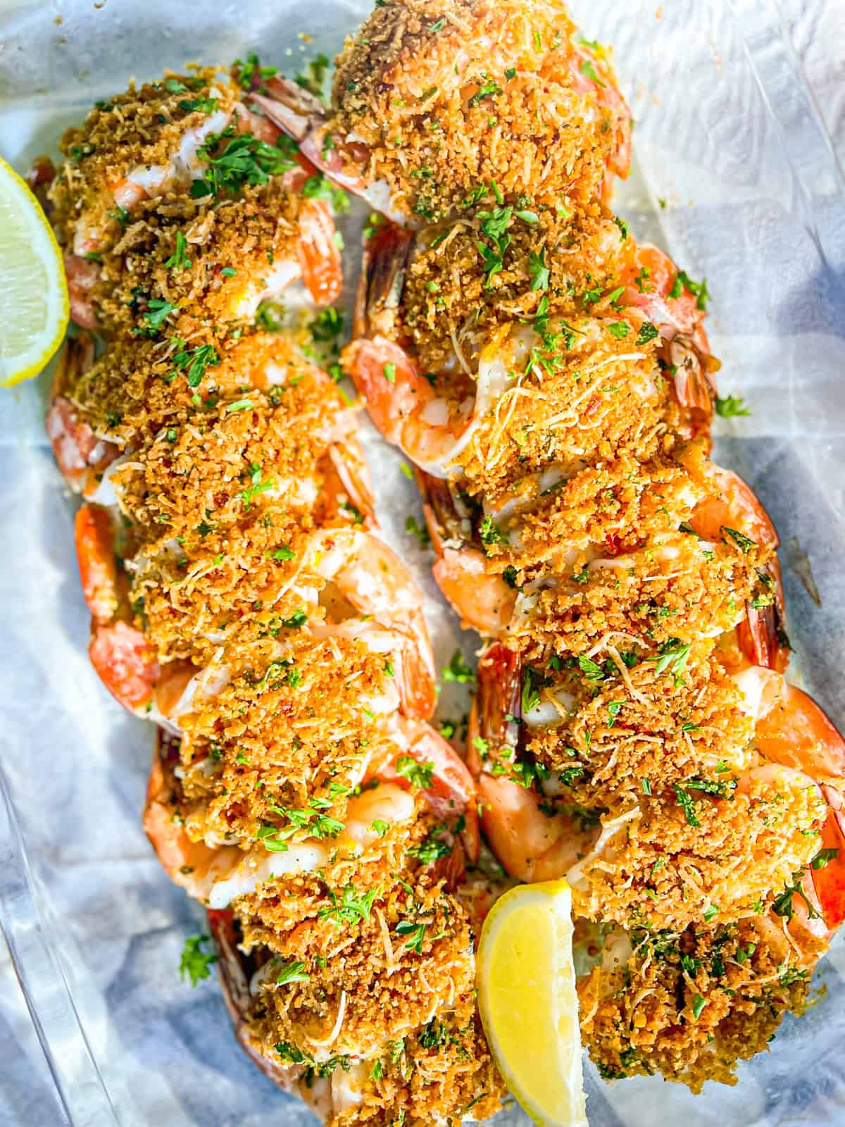 cooked shrimp oreganato in a clear dish.