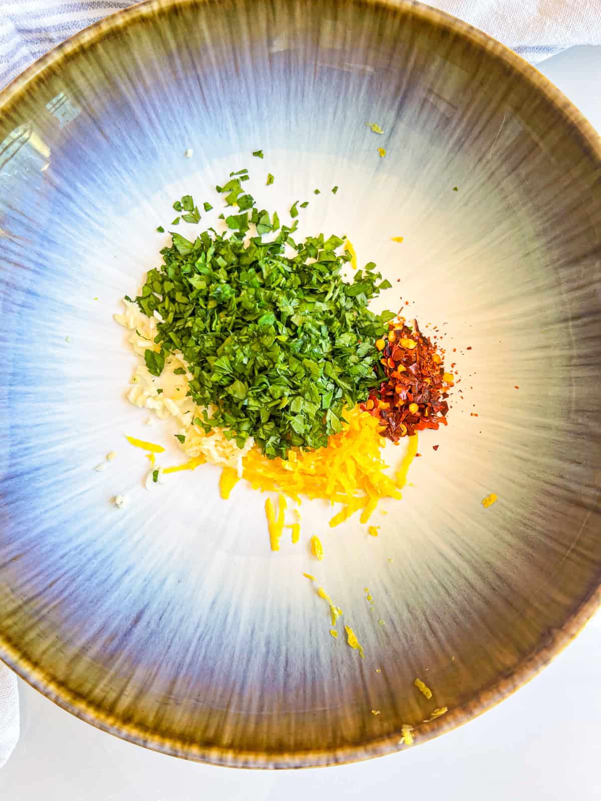 lemon zest with parsley and peppers in a bowl.