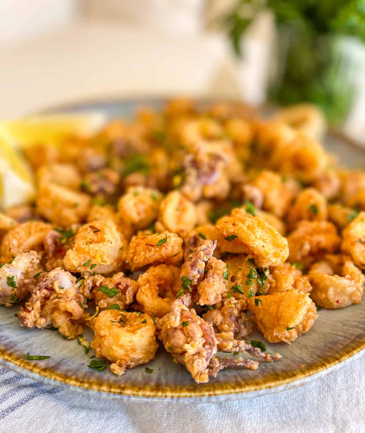 Plate of fried calamari next to some sauce.