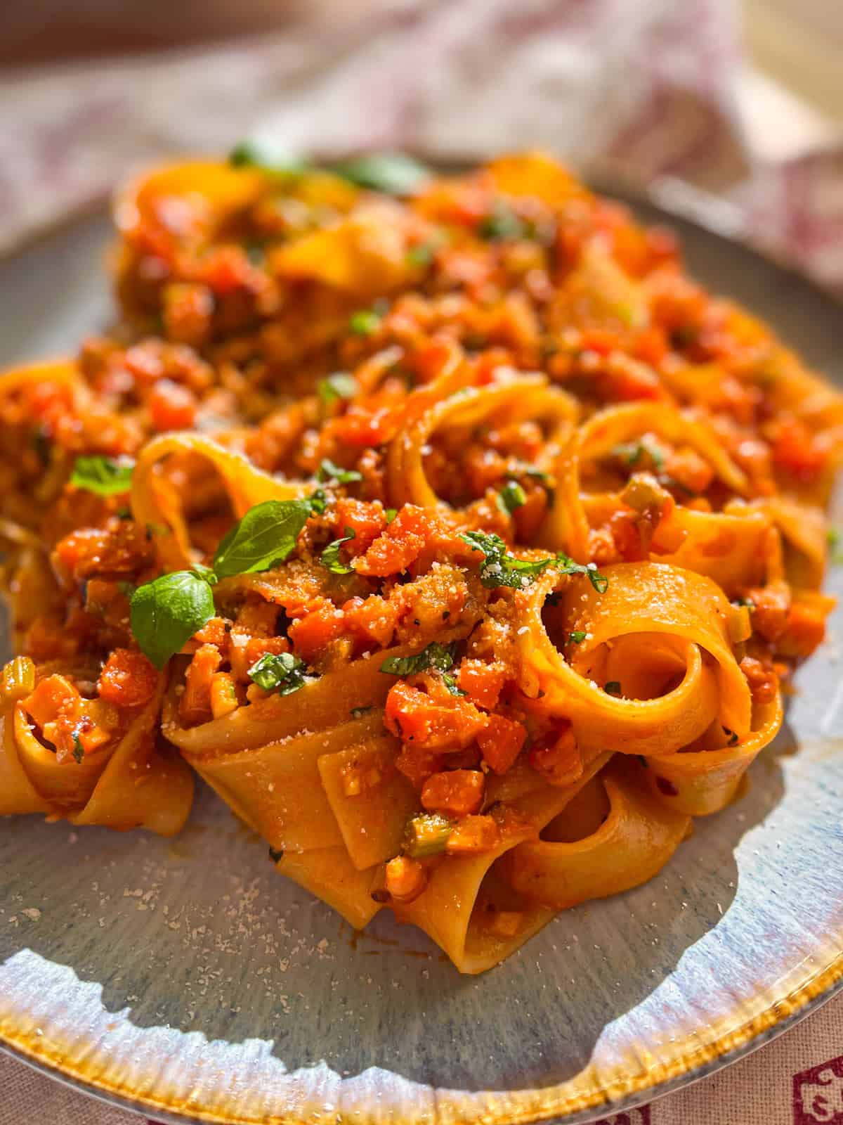 IMG_6989 octopus pasta in a shallow bowl, pappardelle coated in tomato ragu with torn basil and Parmesan.