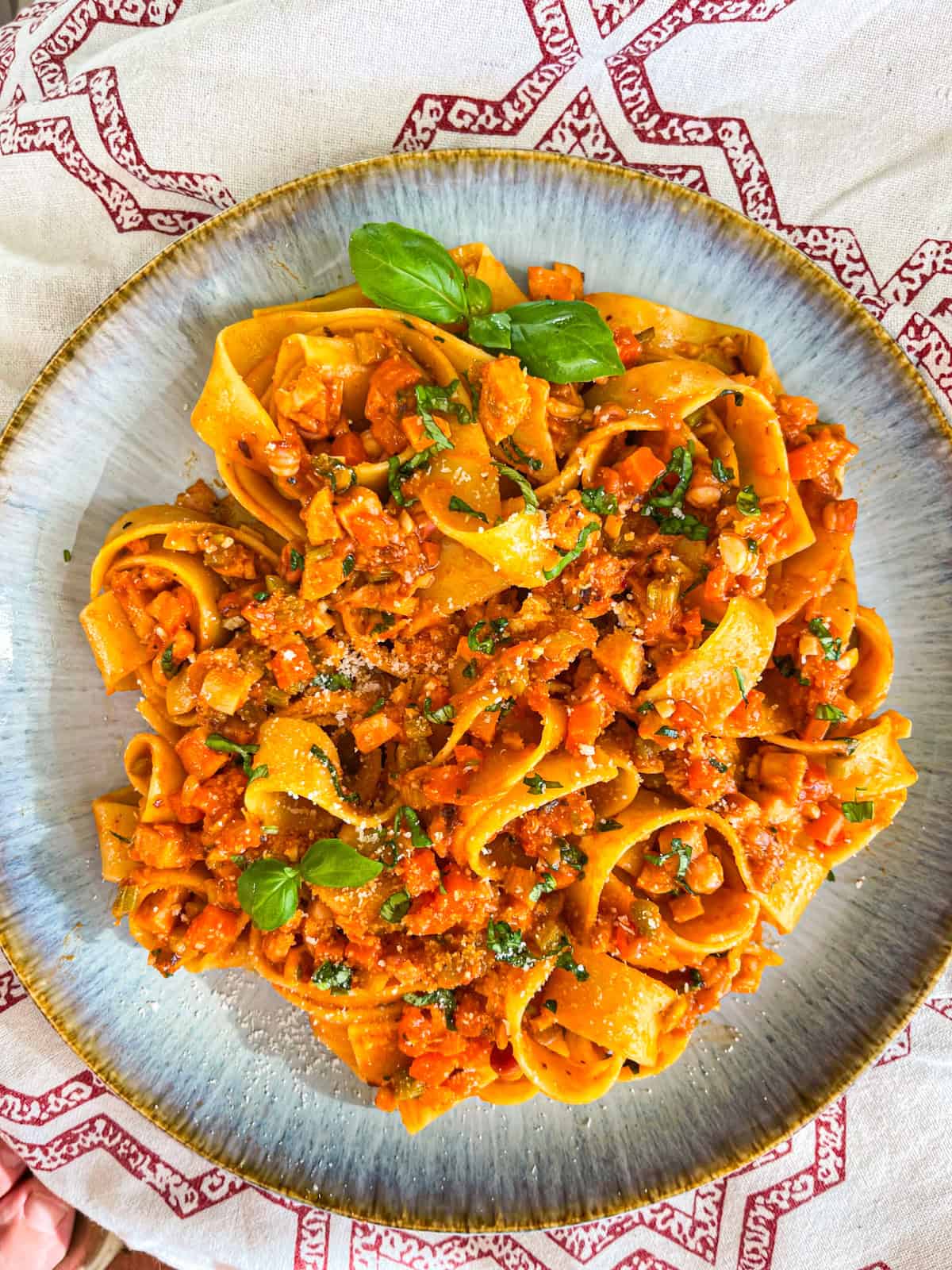 finished octopus pasta with basil leaves and grated Parmesan.