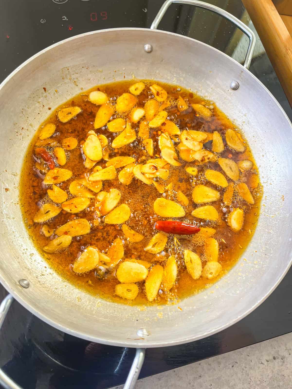 garlic cooking in oil with chili flakes.