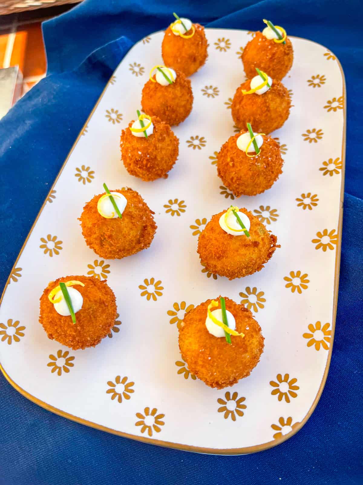 platter of salmon croquetas with lemon wedges.